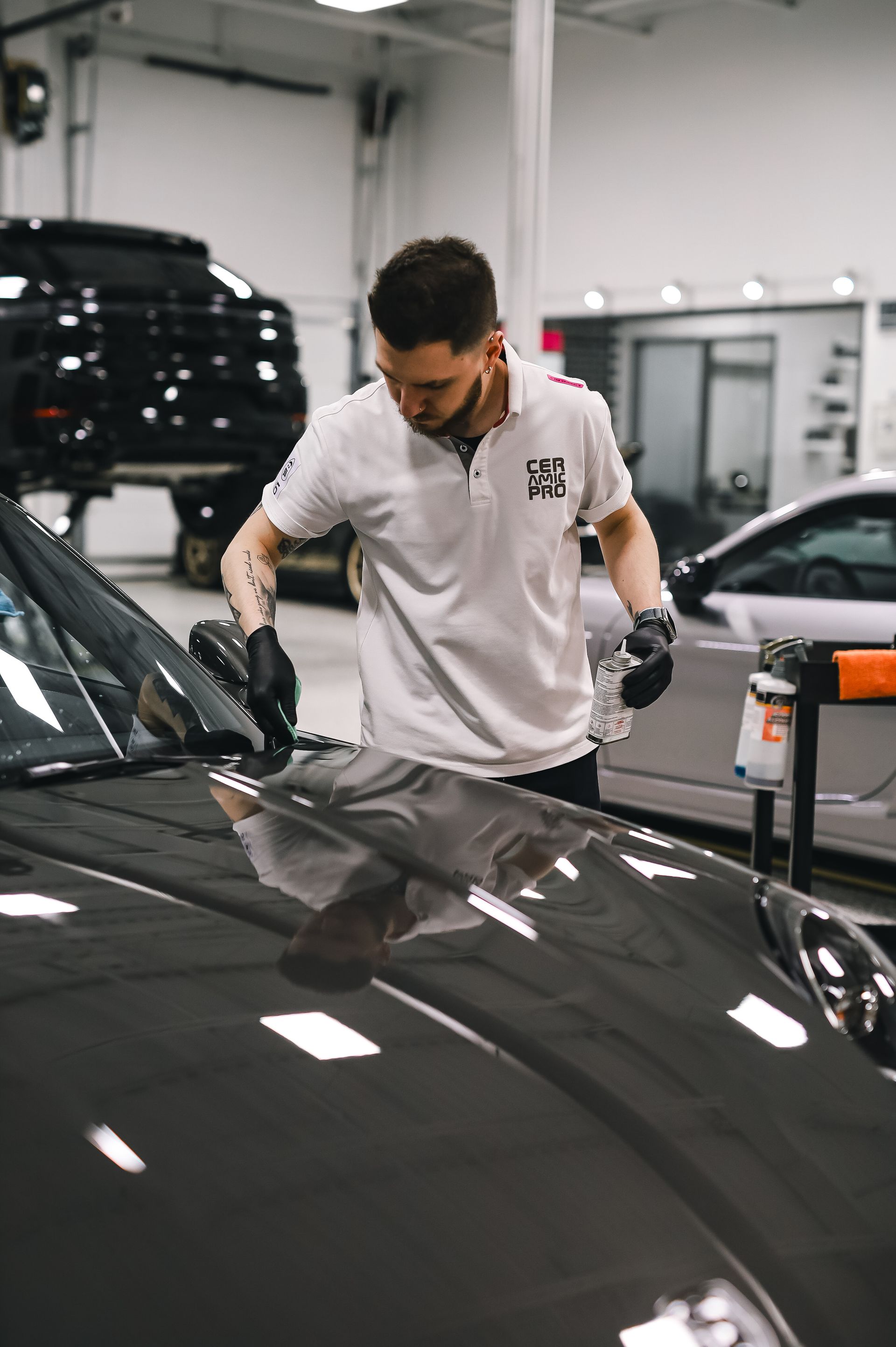 A detailer applying a ceramic coating to a car hood
